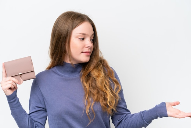 Mujer bonita joven sosteniendo billetera aislada sobre fondo blanco con expresión facial sorpresa