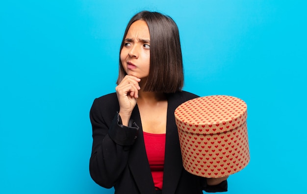 Foto mujer bonita joven sosteniendo una caja de regalo