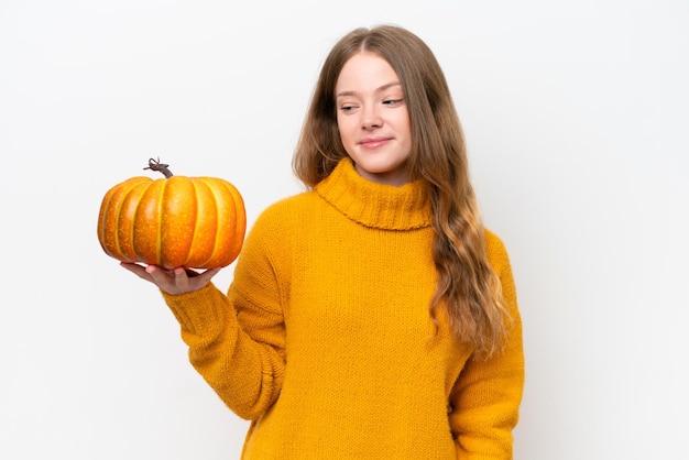 Mujer bonita joven sosteniendo una calabaza aislada sobre fondo blanco con expresión feliz