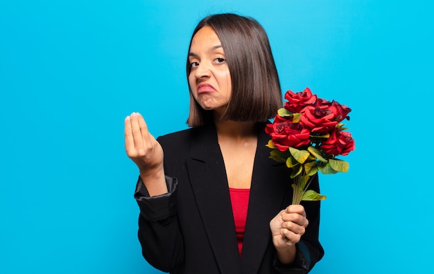 Mujer bonita joven sosteniendo un ramo de rosas