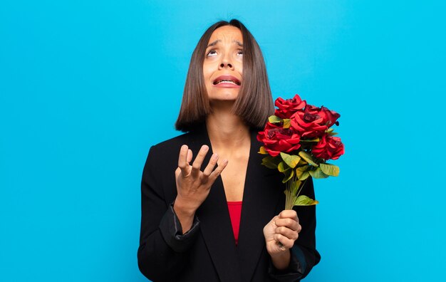 Mujer bonita joven sosteniendo un ramo de rosas