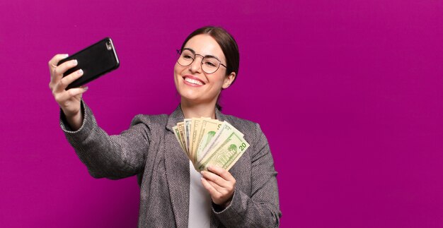 Mujer bonita joven con un teléfono y billetes de dólar. concepto de negocio