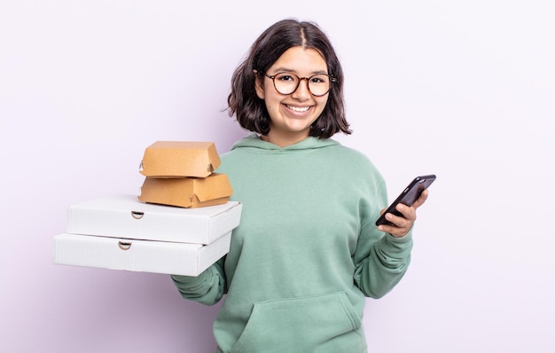 Mujer bonita joven con un teléfono inteligente y el concepto de comida rápida para llevar