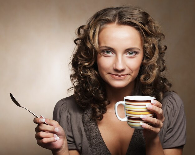 Mujer bonita joven tomando café