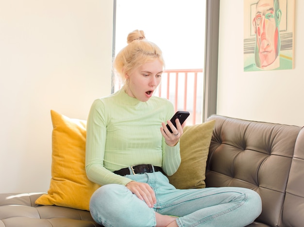 Mujer bonita joven usando su teléfono en casa