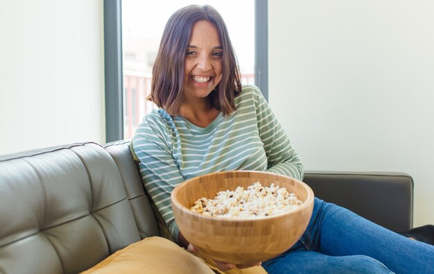 Mujer bonita joven viendo la televisión en casa