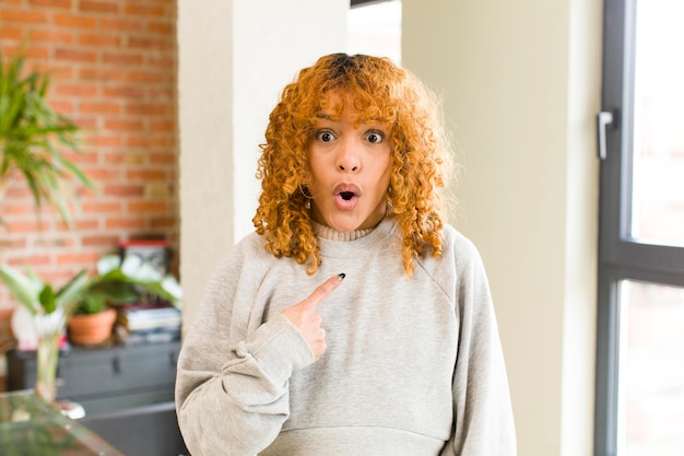 Mujer bonita latina de cabello rojo joven en un nuevo hogar genial