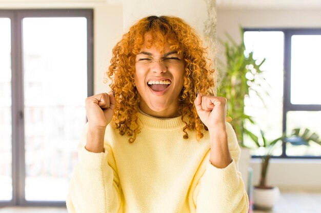 Foto mujer bonita latina de cabello rojo joven en un nuevo hogar genial