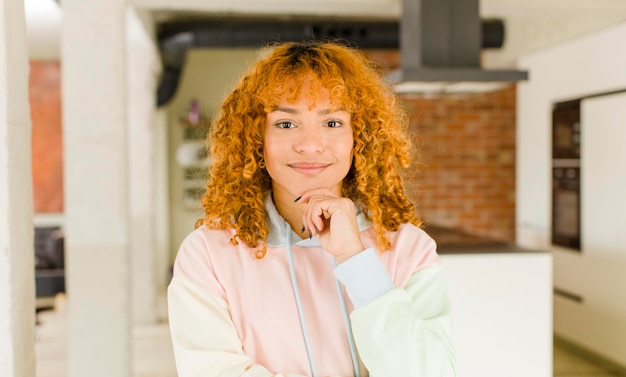 Mujer bonita latina de cabello rojo joven en un nuevo hogar genial