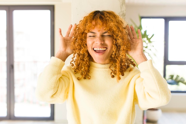 Mujer bonita latina de cabello rojo joven en un nuevo hogar genial