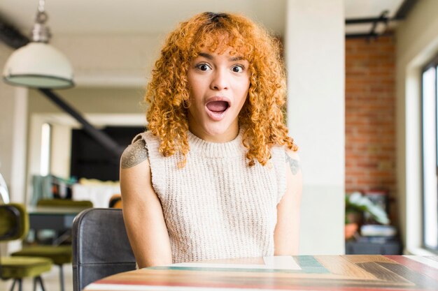 Mujer bonita latina de cabello rojo joven en un nuevo hogar genial