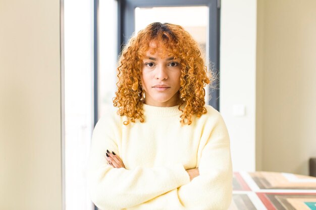 Mujer bonita latina de cabello rojo joven en un nuevo hogar genial