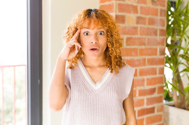 Mujer bonita latina de cabello rojo joven en un nuevo hogar genial