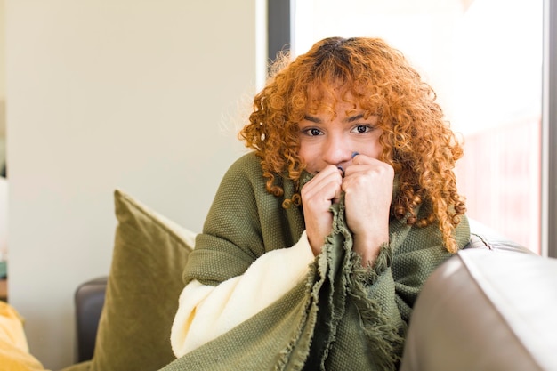 Foto mujer bonita latina de pelo rojo joven descansando en un sofá en casa