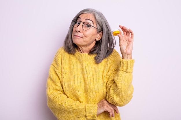 Mujer bonita mayor encogiéndose de hombros, sintiéndose confusa e insegura. concepto de lentes de contacto