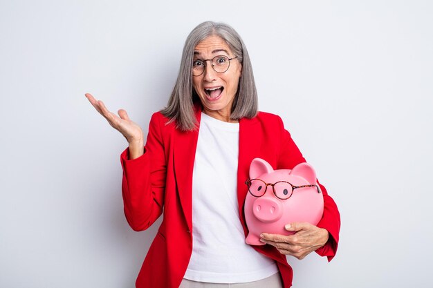 Mujer bonita mayor que se siente feliz y asombrada por algo increíble. concepto de alcancía