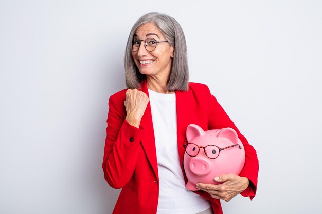 Mujer bonita mayor que se siente feliz y enfrenta un desafío o celebrando. concepto de alcancía