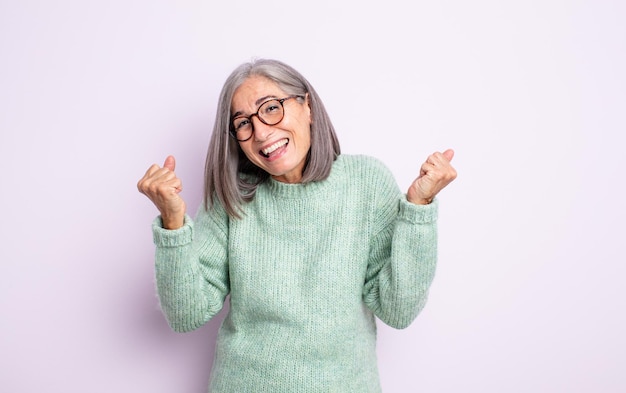 Mujer bonita mayor que se siente feliz, positiva y exitosa, celebrando la victoria, los logros o la buena suerte