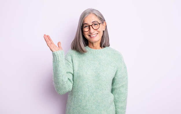 Mujer bonita mayor que se siente feliz sorprendida y alegre sonriendo con actitud positiva al darse cuenta de una solución o idea