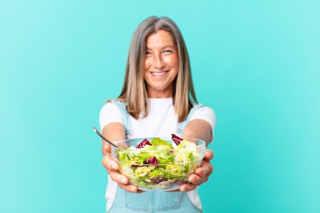 Mujer bonita de mediana edad con una ensalada.