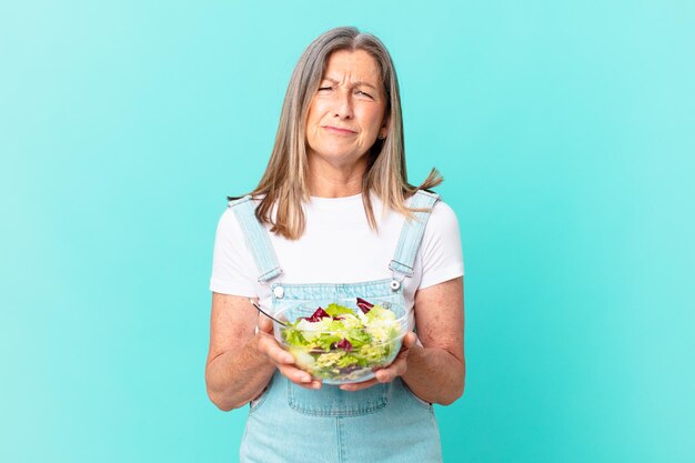 Mujer bonita de mediana edad con una ensalada.