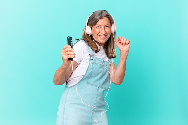 Mujer bonita de mediana edad escuchando música con auriculares