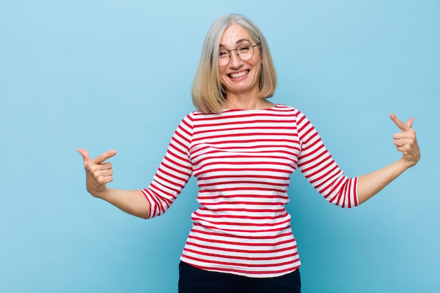 Mujer bonita de mediana edad o mayor que parece orgullosa, arrogante, feliz, sorprendida y satisfecha, apuntando a sí misma, sintiéndose como una ganadora