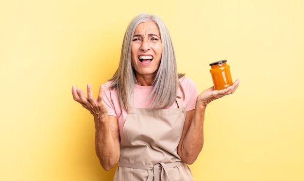 Mujer bonita de mediana edad que parece desesperada, frustrada y estresada. Mermelada de durazno