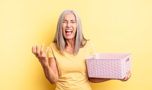 mujer bonita de mediana edad que parece enojada, molesta y frustrada. concepto de cesta vacía