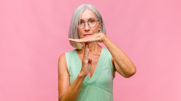 Mujer bonita de mediana edad que parece preocupada, ansiosa, estresada y asustada