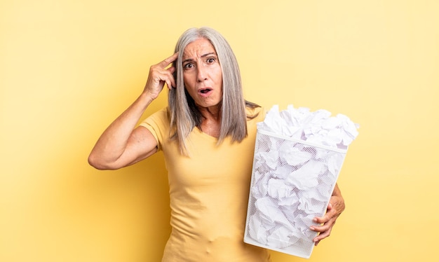 Mujer bonita de mediana edad que parece sorprendida, dándose cuenta de un nuevo pensamiento, idea o concepto. concepto de falla de bolas de papel