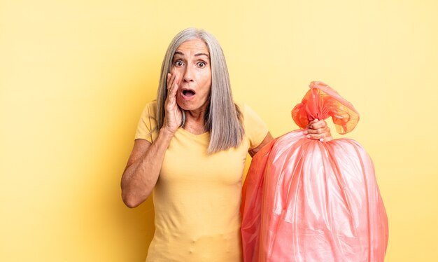 Mujer bonita de mediana edad que se siente conmocionada y asustada. bolsa de plástico para garbaje