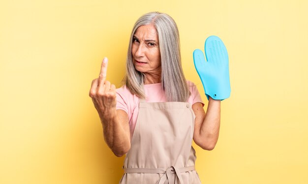 Mujer bonita de mediana edad que se siente enojada, molesta, rebelde y agresiva. concepto de manopla de horno