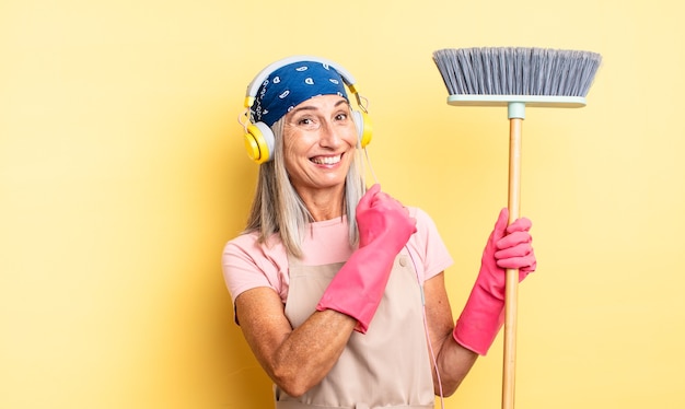 Foto mujer bonita de mediana edad que se siente feliz y enfrenta un desafío o celebración. concepto de hogar y escoba