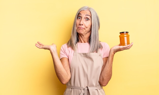 Mujer bonita de mediana edad que se siente perpleja, confundida y dudando. Mermelada de durazno