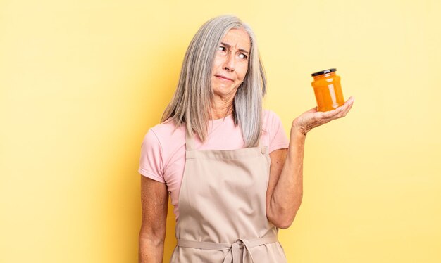 Mujer bonita de mediana edad que se siente triste, molesta o enojada y mira hacia un lado. Mermelada de durazno