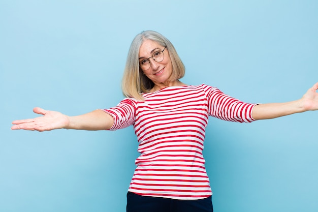 Mujer bonita de mediana edad sonriendo alegremente dando un cálido abrazo