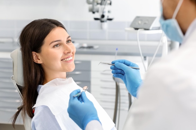 Una mujer bonita mirando al dentista con confianza