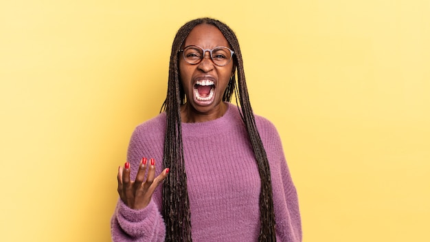 Mujer bonita negra afro que parece enojada, molesta y frustrada gritando wtf o qué te pasa