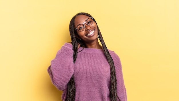 Mujer bonita negra afro riendo alegre y confiadamente con una sonrisa casual, feliz y amistosa