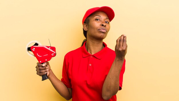 Mujer bonita negra haciendo capice o gesto de dinero diciéndote que pagues