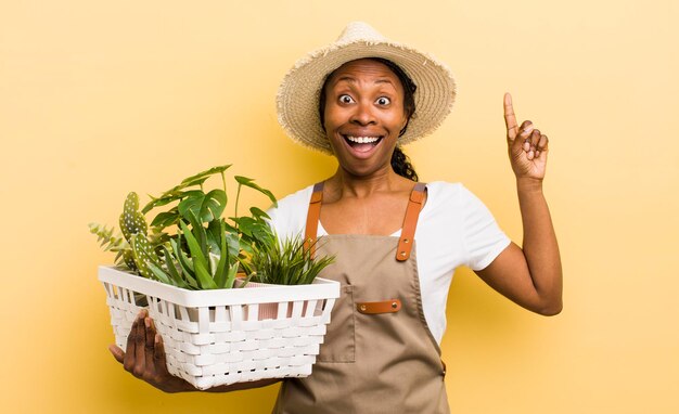 Mujer bonita negra que se siente como un genio feliz y emocionado después de darse cuenta de una idea