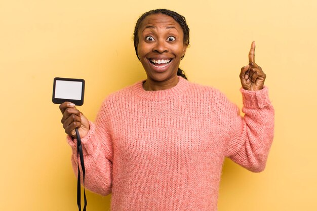 Mujer bonita negra que se siente como un genio feliz y emocionado después de darse cuenta de una idea