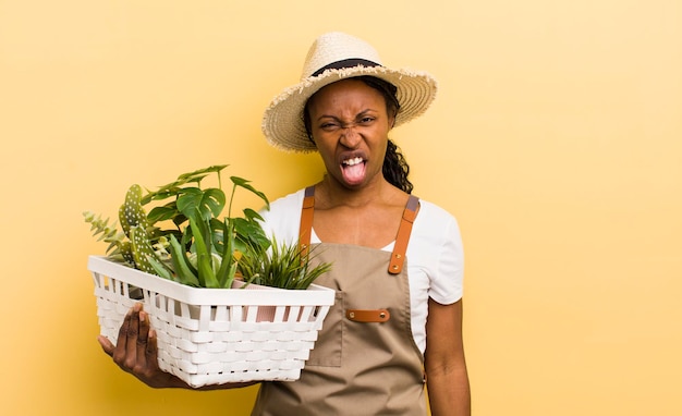 Mujer bonita negra que se siente disgustada e irritada y saca la lengua