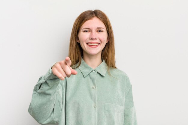 Mujer bonita pelirroja apuntando a la cámara con una sonrisa satisfecha y segura de sí misma eligiéndote