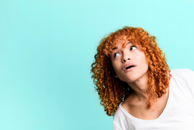 Mujer bonita pelirroja con un espacio de copia al lado que presenta algo