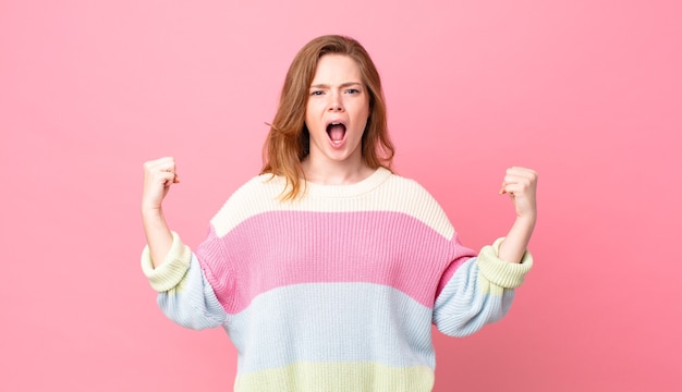 Mujer bonita pelirroja gritando agresivamente con una expresión enojada