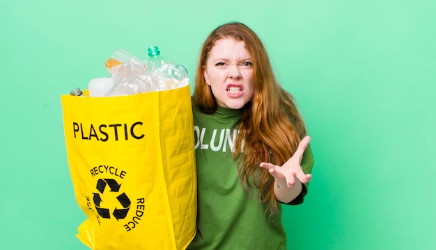 Mujer bonita pelirroja que parece enojada, molesta y frustrada, concepto de reciclaje