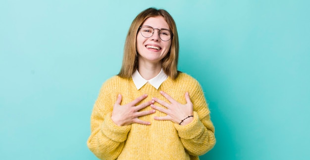 Mujer bonita pelirroja que parece feliz sorprendida orgullosa y emocionada señalándose a sí misma