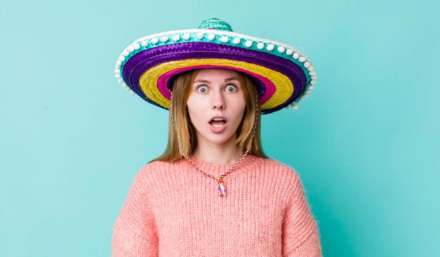 Mujer bonita pelirroja que parece muy sorprendida o sorprendida concepto de sombrero mexicano